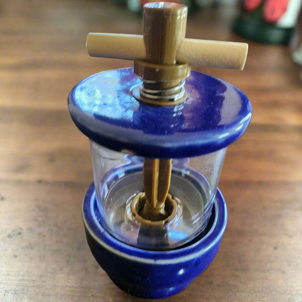 Blue Herb Grinder on dark wood table top. Clear acrylic sides.