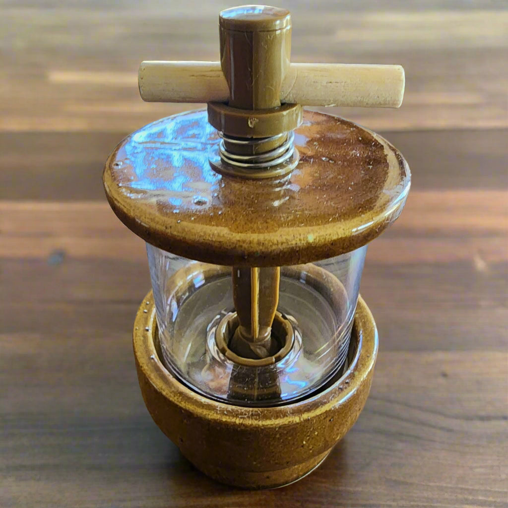 Gold Pako Lazo Pottery Herb Grinder on dark wood kitchen table